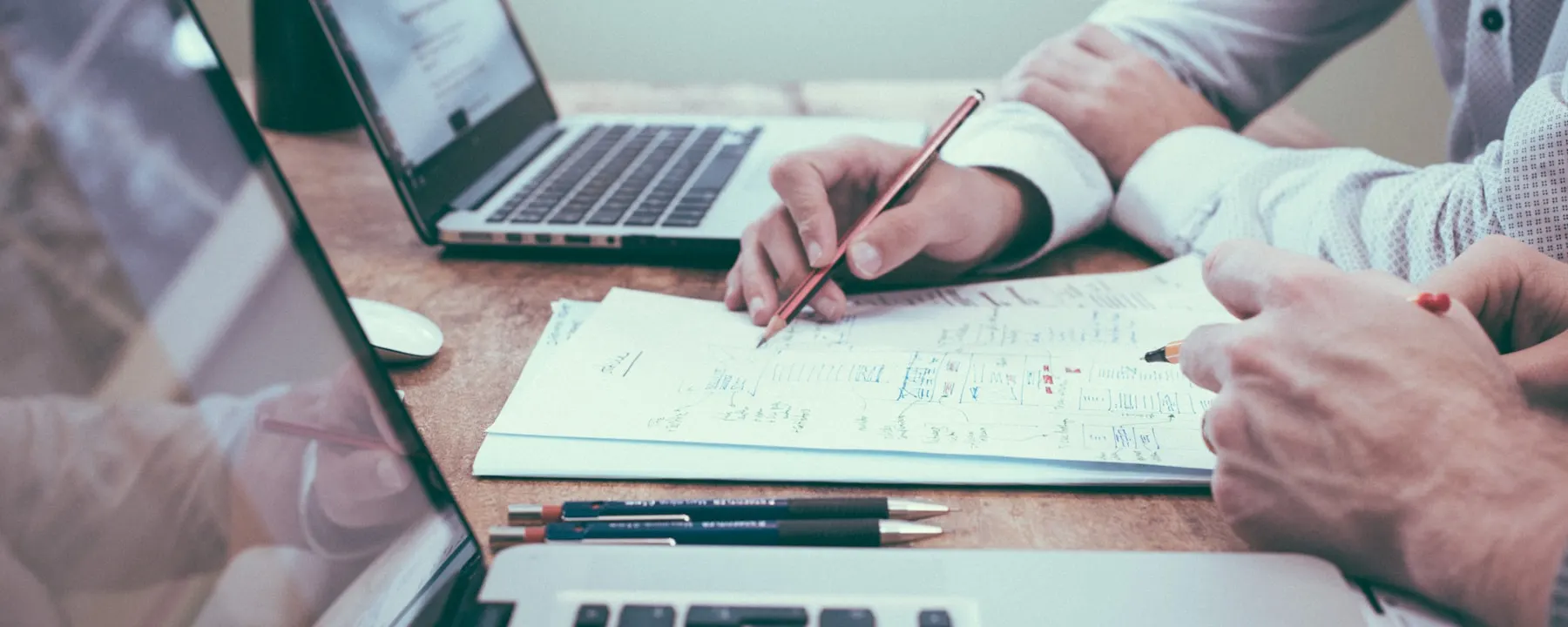 Tavolo di lavoro con appunti, grafici e laptop durante la pianificazione strategica di un progetto